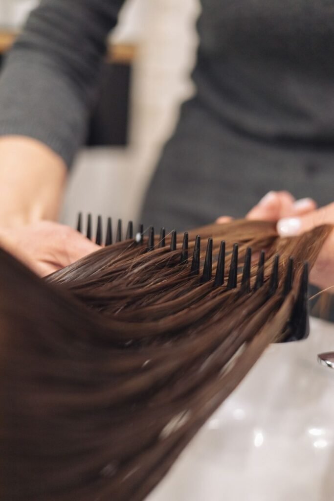 a hairdresser combing clients hair